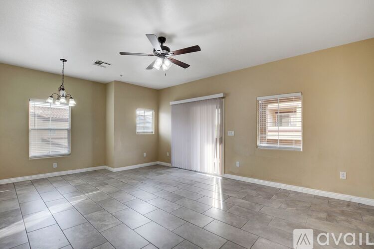 A spacious room with a ceiling fan and tile flooring.