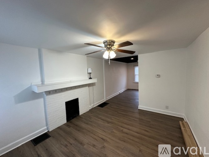 A room with a fireplace and a ceiling fan.