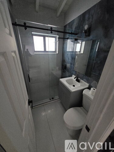 A bathroom with a toilet, sink, and shower.