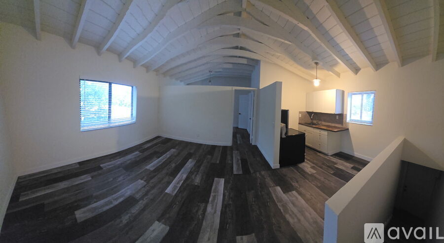A room with wooden flooring and a skylight.