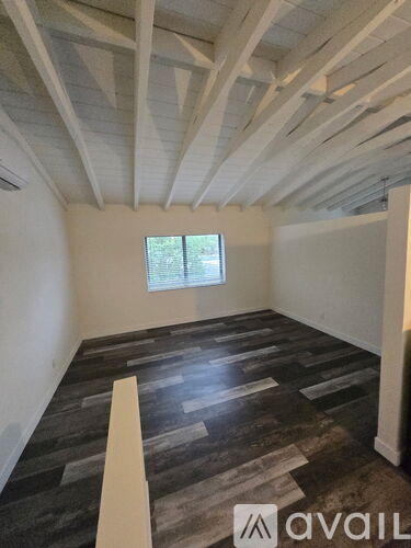 A room with wooden flooring and a window.