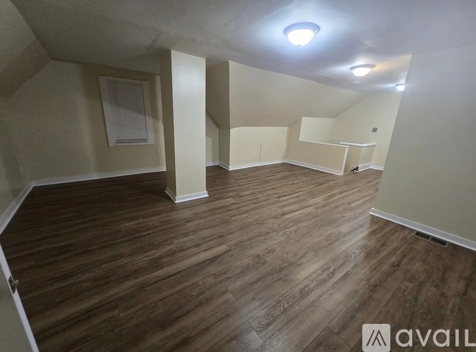 A room with wooden flooring and a white ceiling.