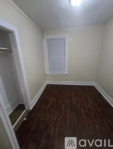 A room with a window and wooden flooring.