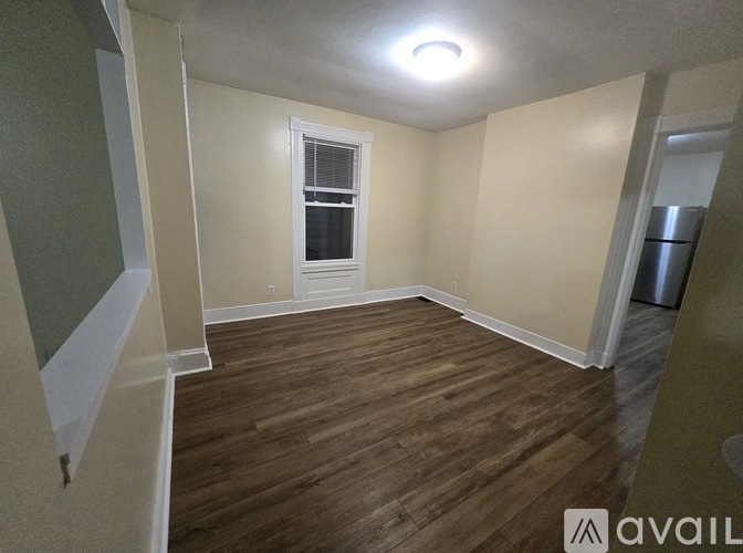 A room with wooden flooring and a window.