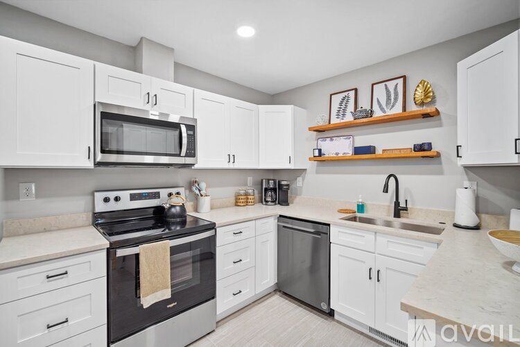 A modern kitchen with white cabinets and a black stove top.