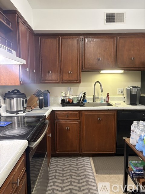 A kitchen with wooden cabinets and a black stove top.
