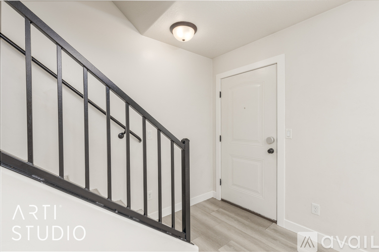 A staircase with a black railing and a white door.