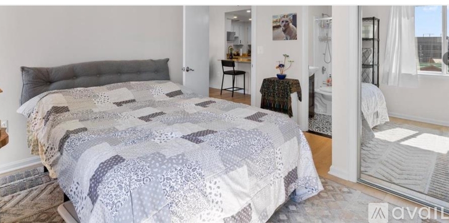 A bedroom with a large bed and a mirror on the wall.