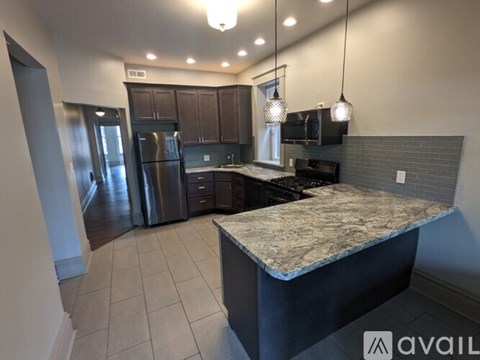 A kitchen with a marble countertop and stainless steel appliances.