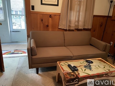 A tan couch sits in a living room with a coffee table in front of it.