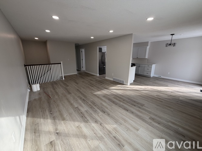 A spacious room with wooden flooring and a white ceiling.