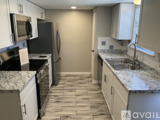 A kitchen with granite countertops and tile flooring.