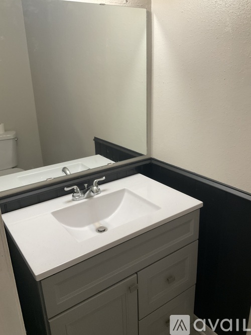 A white sink with a black counter top.