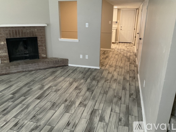 A living room with a fireplace and wood flooring.