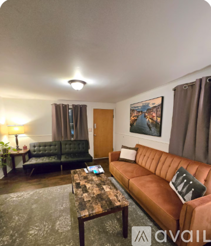 A living room with a brown leather couch and a wooden coffee table.