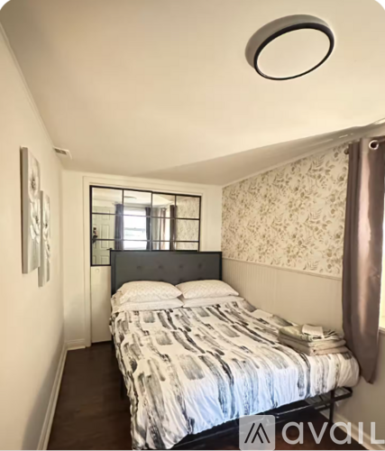 A bedroom with a bed and a window.