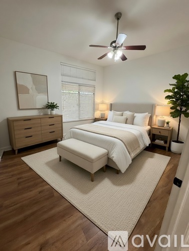 A bedroom with a bed, nightstands, and a ceiling fan.
