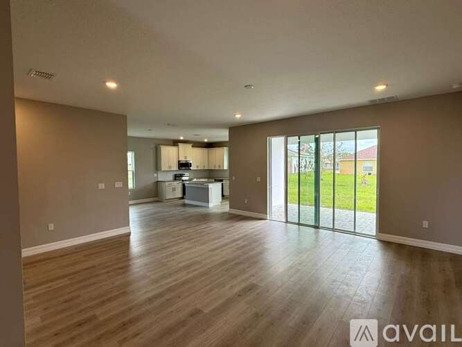 A spacious living room with hardwood floors and a large window.