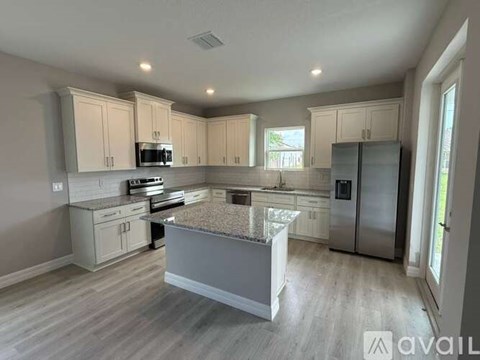 A kitchen with a granite countertop and stainless steel appliances.
