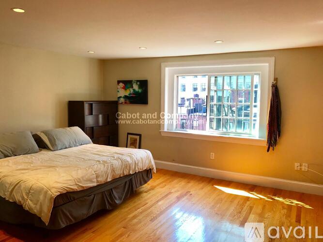 A bedroom with a large bed and a window overlooking a city street.