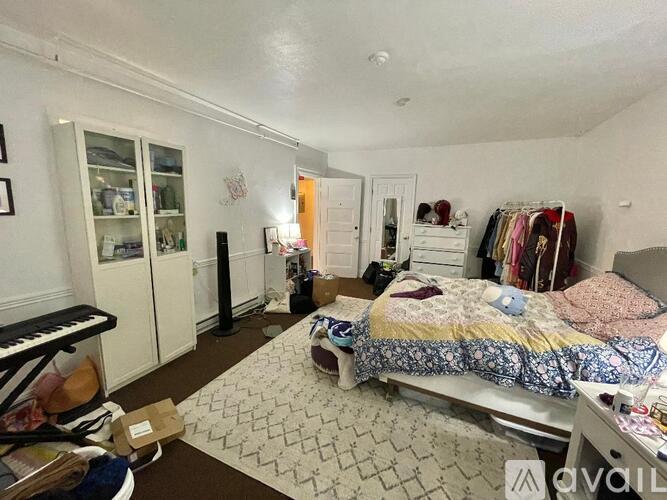 A bedroom with a bed, dresser, and wardrobe.