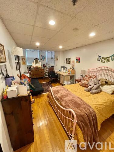 A bedroom with a bed, a desk, and a chair.