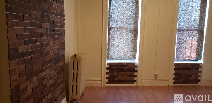 A room with a brick wall and a window.