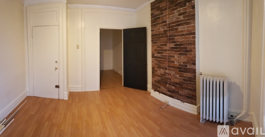A room with a brick wall and a white radiator.