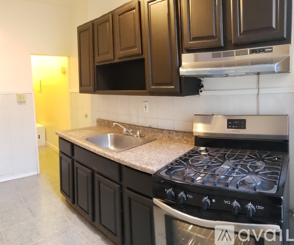 A kitchen with a black stove top oven and black cabinets.