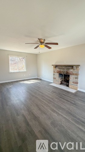 A room with a fireplace and a ceiling fan.