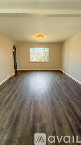 A room with wooden flooring and a window.