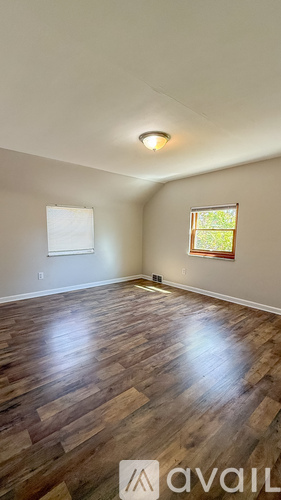 A room with wooden flooring and a window.