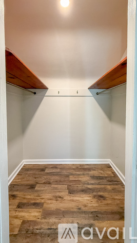A hallway with wooden floors and white walls.