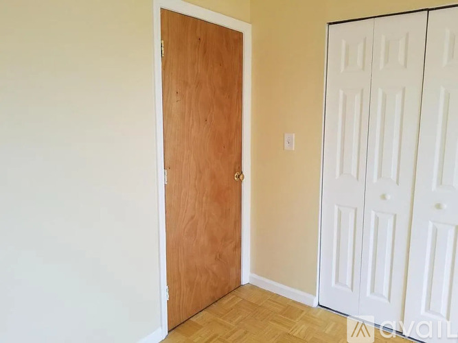 A room with a brown door and white walls.