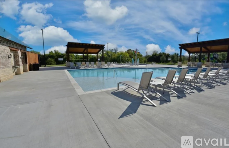A pool area with sun loungers and a covered area.