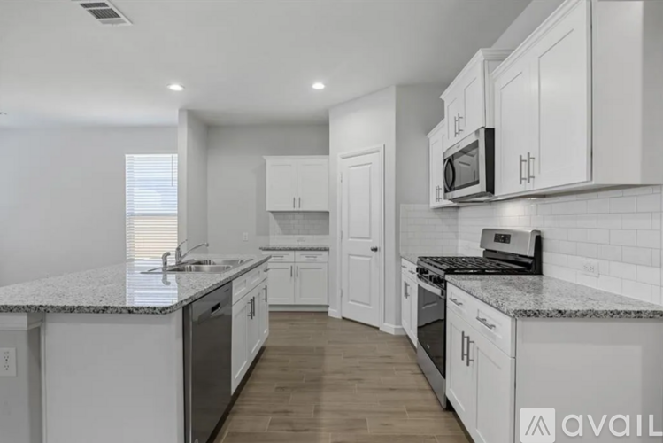 A kitchen with white cabinets and a granite countertop.