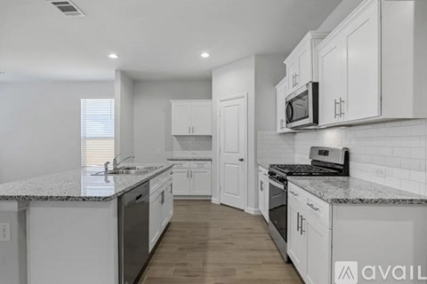 A kitchen with white cabinets and a granite countertop.