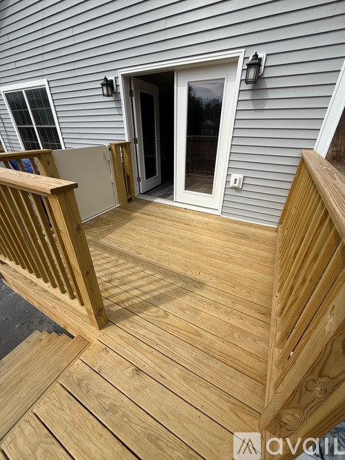 A wooden deck with a white door and window.