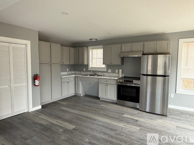 A kitchen with a stainless steel refrigerator, oven, and sink.