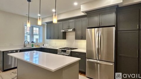 A modern kitchen with a stainless steel refrigerator and a white countertop.