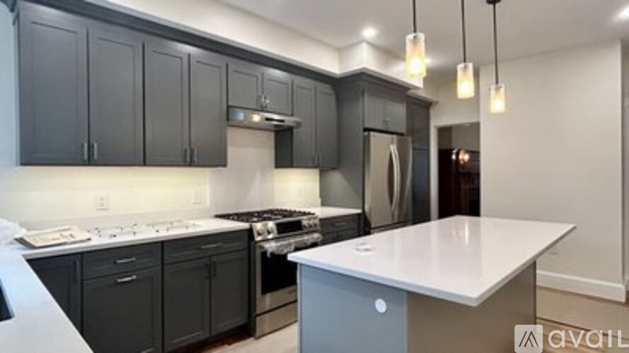 A kitchen with black cabinets and a white countertop.