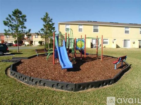 A playground with a blue slide and a red bench.