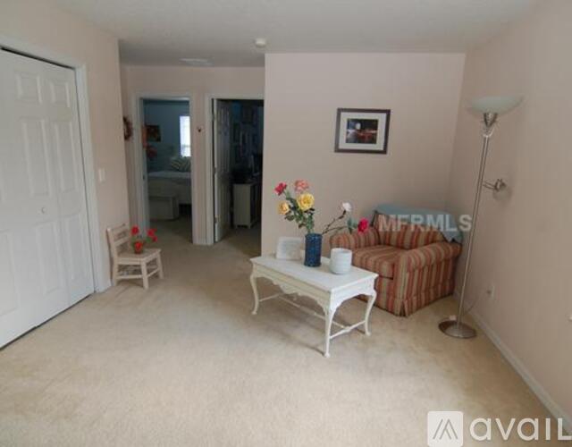 A living room with a white coffee table and a brown striped couch.