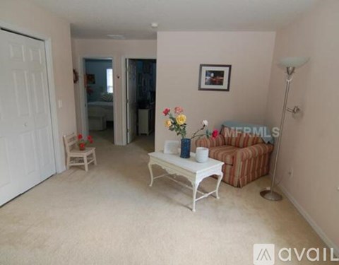 A living room with a white coffee table and a brown striped couch.