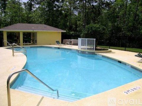 A pool with a metal railing and steps leading into it.
