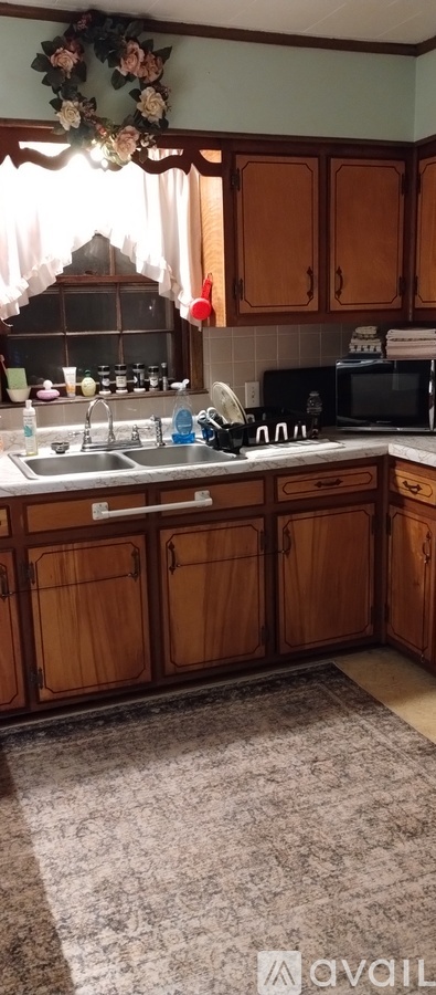 A kitchen with wooden cabinets and a floral decoration.