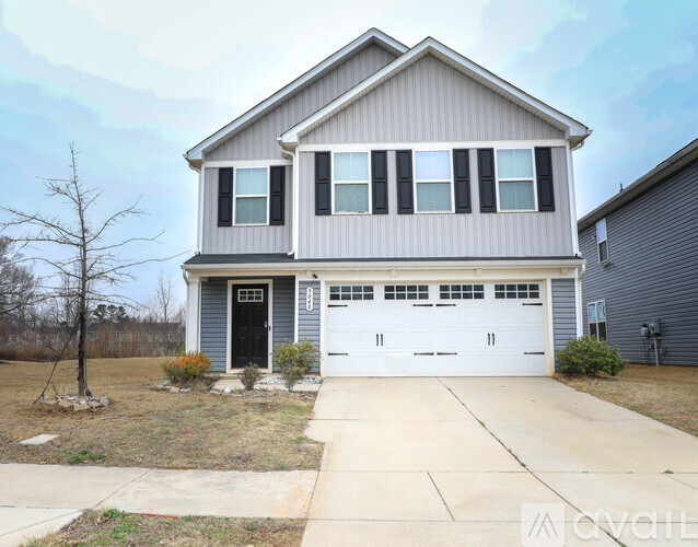 A two-story house with a garage and a driveway.