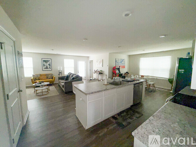 A kitchen with white cabinets and a marble countertop.