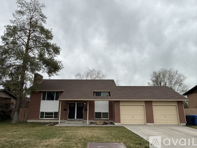 A house with a brown roof and a tree in front of it.