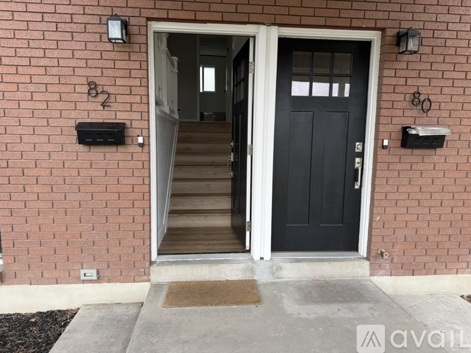A black door is open to a white interior.